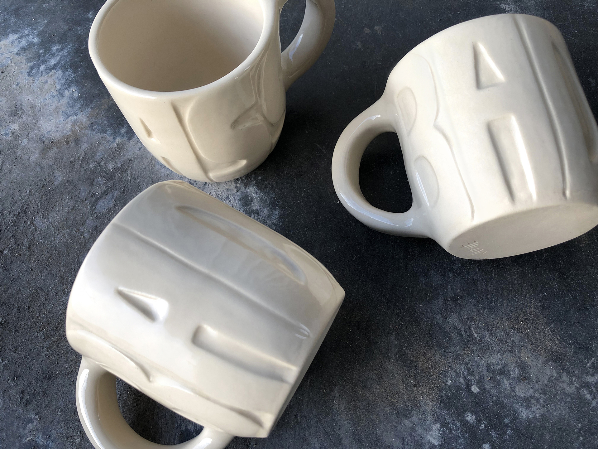 Linda Ra work titled Badass Espresso Mug with bold raised letterfroms embossed on the mugs.