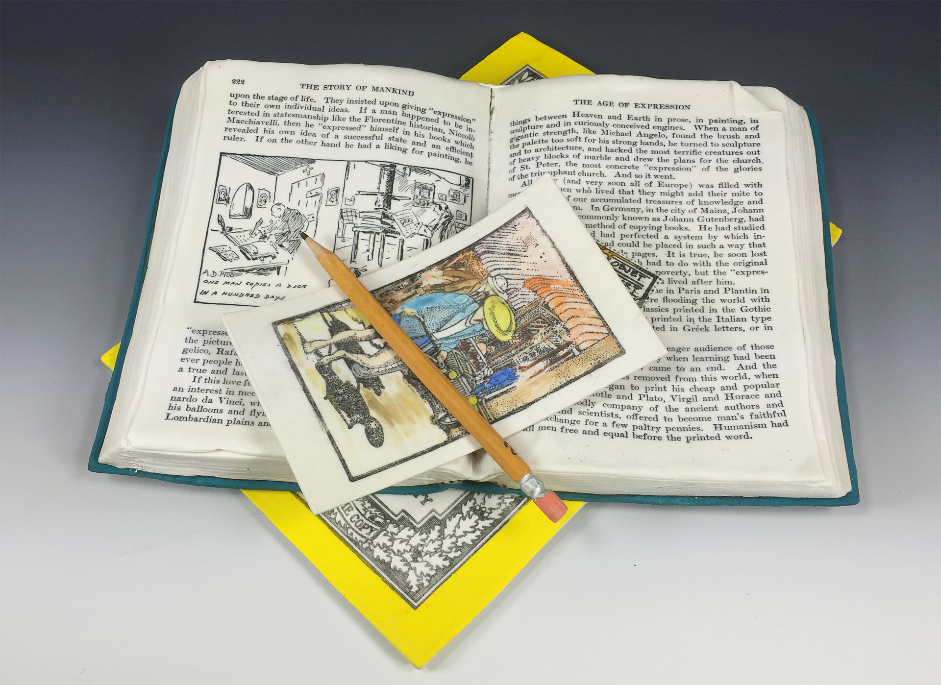 Suzanne Sidebottom used porcelain clay, underglazes and ceramic decals to create a realistic image of an open book, a pencil and other printed objects.